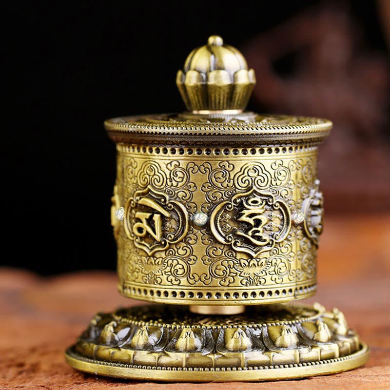 Handcrafted lotus prayer wheel ornament featuring sacred Buddhist symbols, overhead studio angle