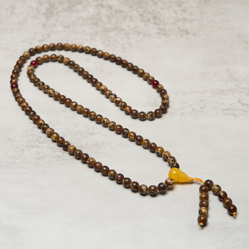 Full-length 108 bead Buddhist prayer mala necklace with gourd charm pendant and red accent beads - flat lay