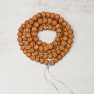 108 Bodhi seed prayer mala beads overhead flat lay view showing complete brown bead strand with silver tassel on grey background