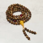 108 amber mala beads with yellow guru bead and red accent beads, featuring gourd charm tassel pendant - top view