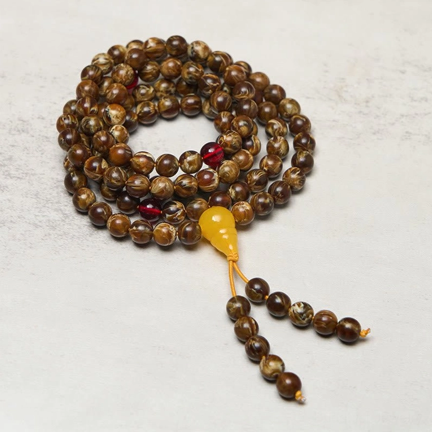 108 amber mala beads with yellow guru bead and red accent beads, featuring gourd charm tassel pendant - top view