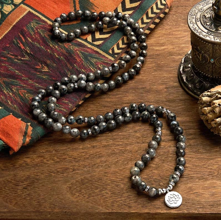 Scattered multi-strand black glitter stone mala beads with lotus pendant on ethnic patterned cloth