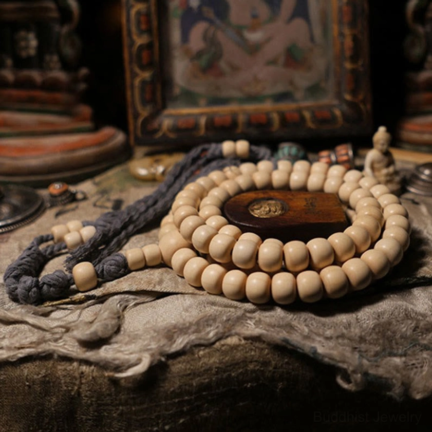 Buddhist prayer mala bracelet on linen cloth with wooden spacer bead and small Buddha figurine