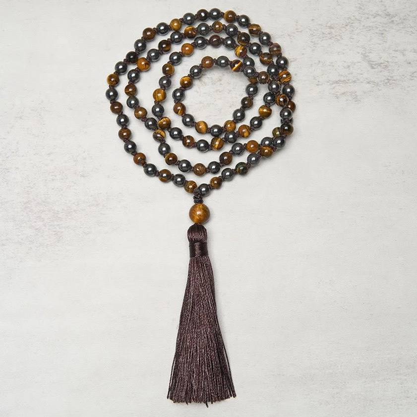 Buddhist prayer mala 108 beads flat lay with centered bead loop and tiger eye accent