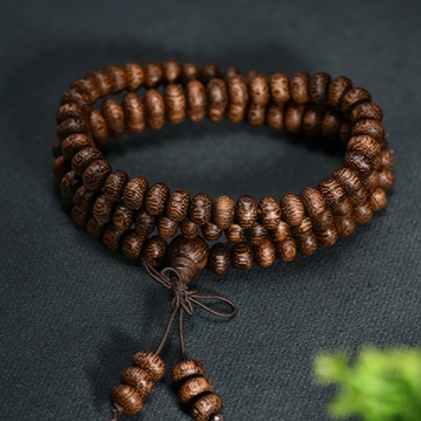 Round natural wood prayer beads mala necklace with decorative knot tassel, overhead flat lay photography