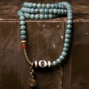108 bodhi seed mala beads bracelet with hand-painted dzi bead pendant and brass accents displayed overhead