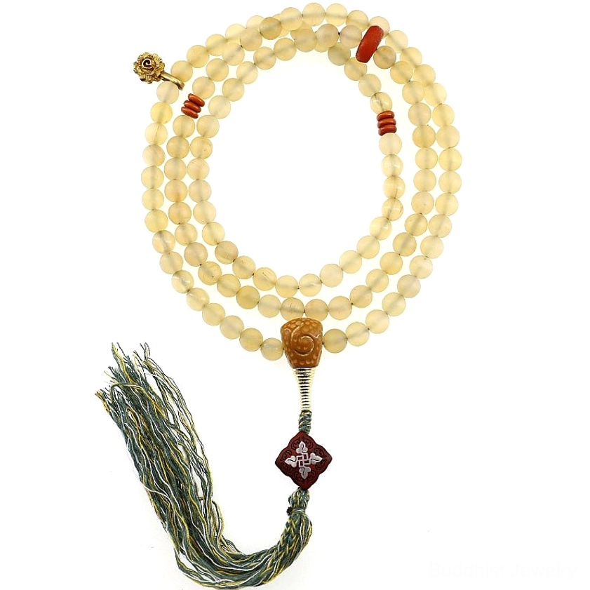 Complete 108 bead mala prayer bracelet flat lay showing amber and sheep horn beads with carved guru bead