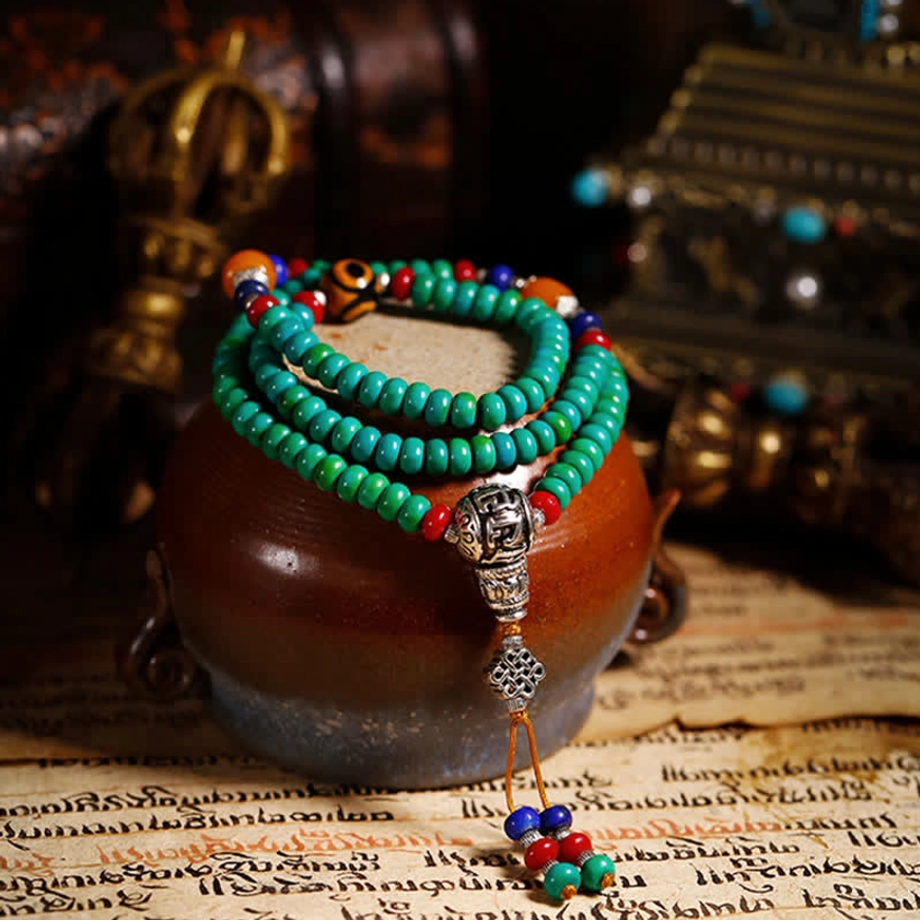 Stacked Buddhist 108-bead mala bracelet on traditional paper with turquoise and accent beads