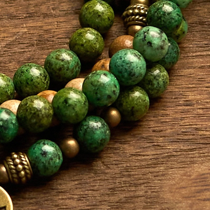 Detailed close-up of mala beads showing round natural stone beads with bronze metal spacer beads