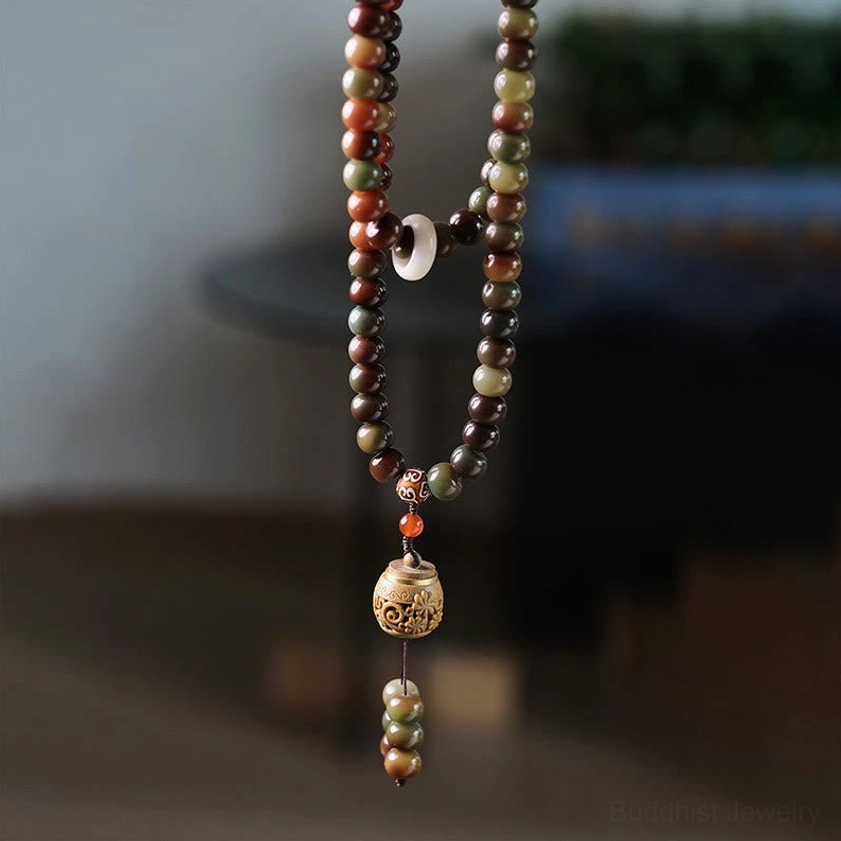 Authentic 108 Buddhist prayer mala beads with carved wooden pendant and bead tassel, flat lay studio shot