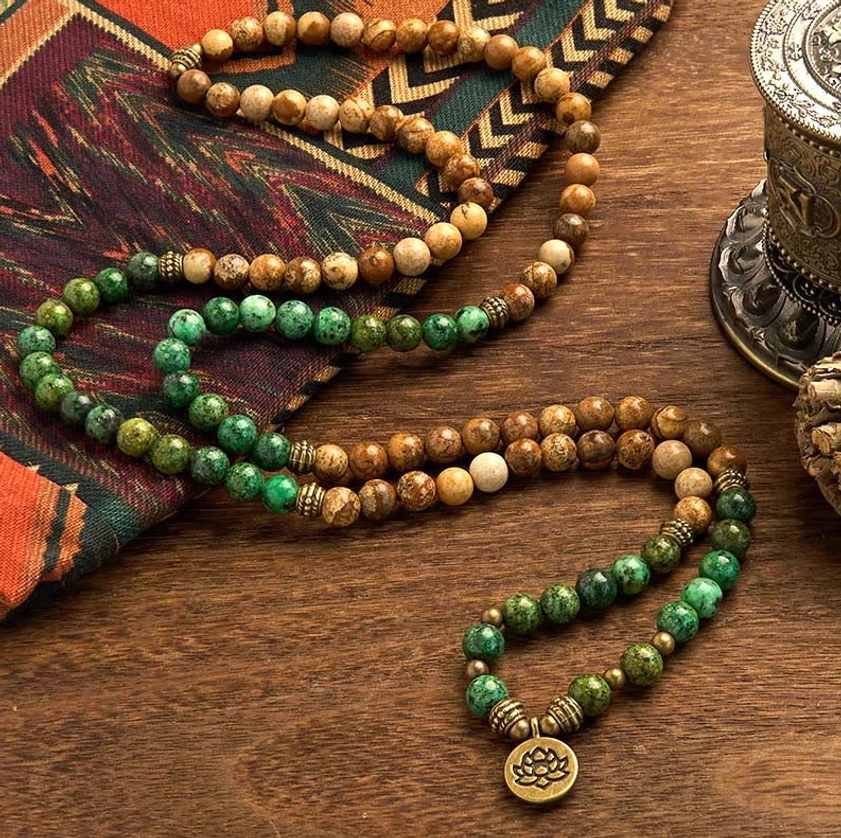 Two strands of 108 Buddhist prayer mala beads with mixed stone beads and metal lotus charm on vintage fabric