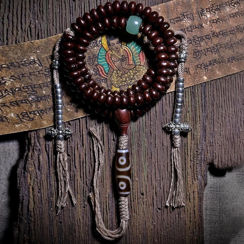Buddhist prayer mala 108 beads with purple bodhi seeds and dzi bead pendant on meditation cloth