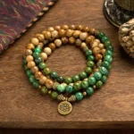 108-bead mala bracelet with picture jasper and turquoise beads featuring engraved lotus pendant charm, flat lay view