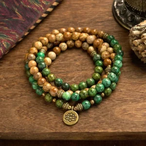 108-bead mala bracelet with picture jasper and turquoise beads featuring engraved lotus pendant charm, flat lay view