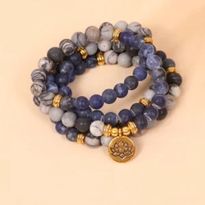 108 bead mala bracelet with sodalite zebra jasper and gold lotus charm on pink background