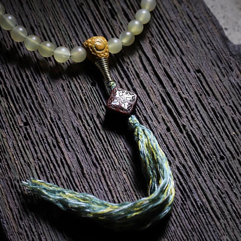 108 bead mala bracelet showing sheep horn and amber materials with spiritual meditation use