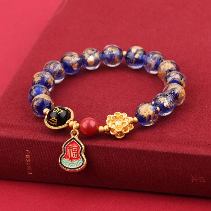 10mm blue Liuli glass Buddhist bracelet with speckled beads, gold lotus charm, and sacred pendant on red book