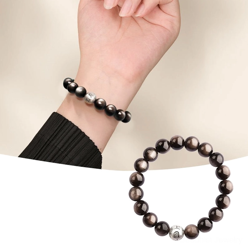 Silver Sheen Obsidian 10mm bead Buddhist bracelet with sterling silver engraved mantra charm in flat lay composition