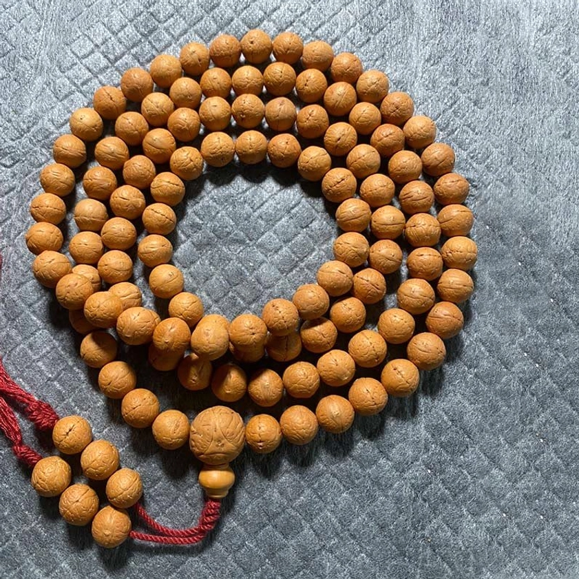 11.5mm Bodhi seed 108 mala beads with red tassel and wooden guru bead, grey quilted background