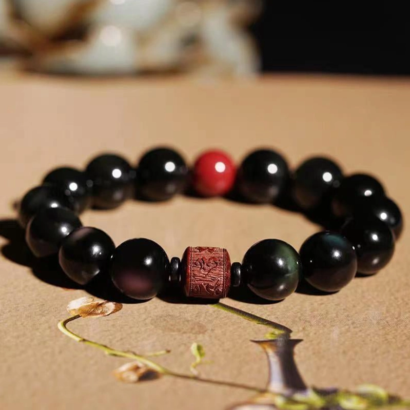 12mm Rainbow Obsidian Cinnabar Om Mani Padme Hum bracelet with prominent spiritual symbol for maximum impact
