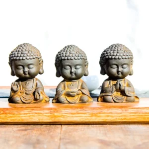 Three handcrafted Buddhist meditation Buddha statues in iron powder resin with different mudra hand gestures set displayed together on wooden tray