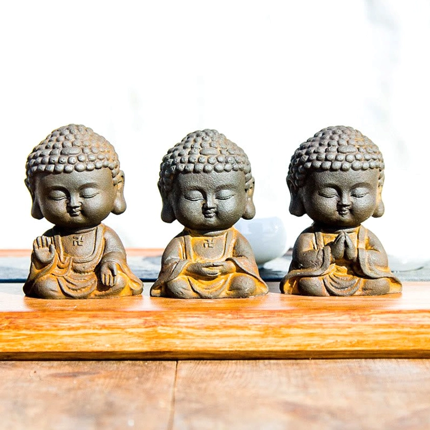 Three handcrafted Buddhist meditation Buddha statues in iron powder resin with different mudra hand gestures set displayed together on wooden tray