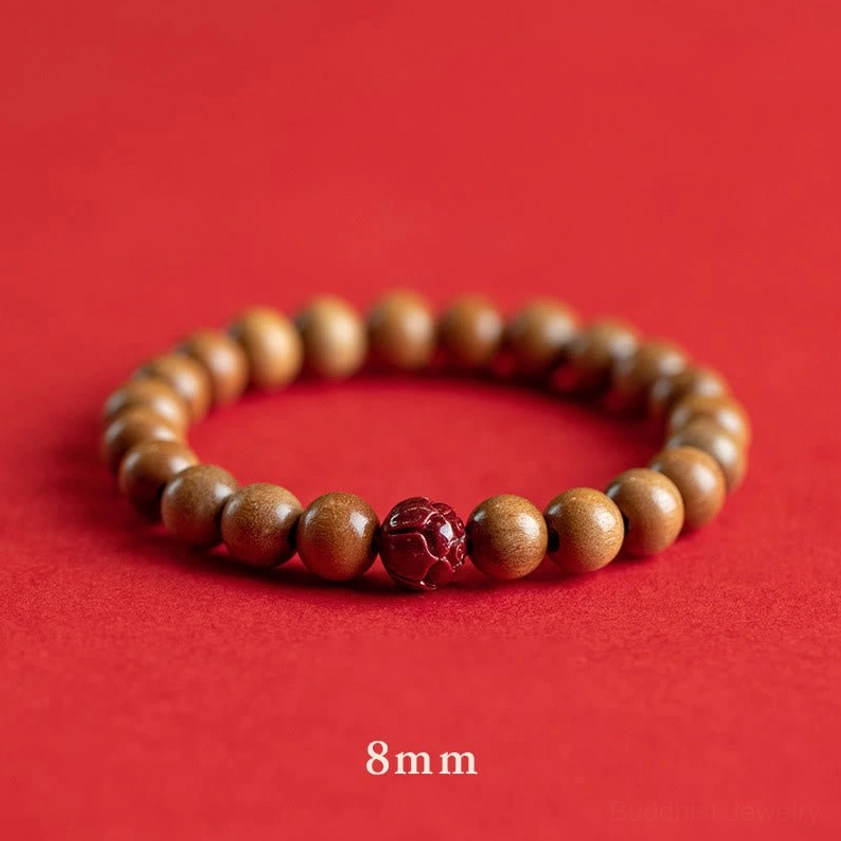 8mm peach wood and cinnabar lotus bracelet flat lay, demonstrating larger bead size with carved red lotus accent