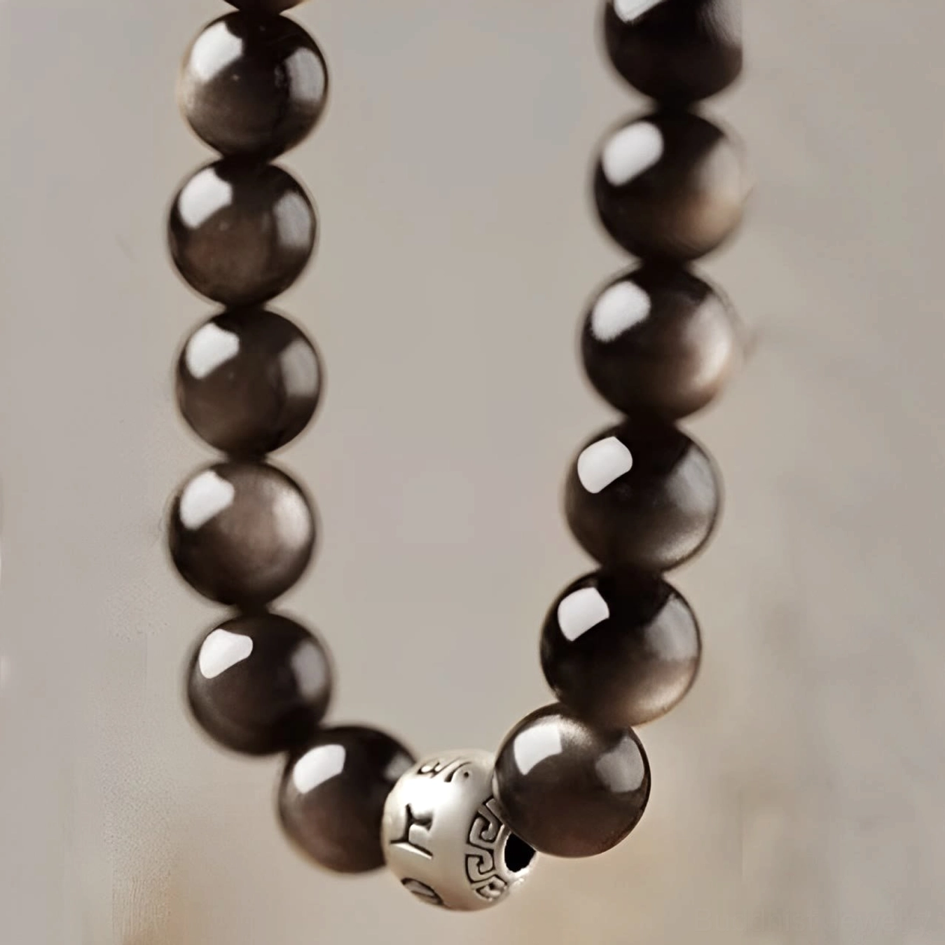 Silver Sheen Obsidian 8mm bead Buddhist bracelet with engraved Om Mani Padme Hum charm in balanced minimalist style