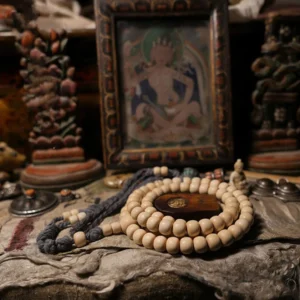 108 bead Abelia Biflora wood Buddhist prayer mala bracelet flat lay with wooden spacer and dark grey tassel