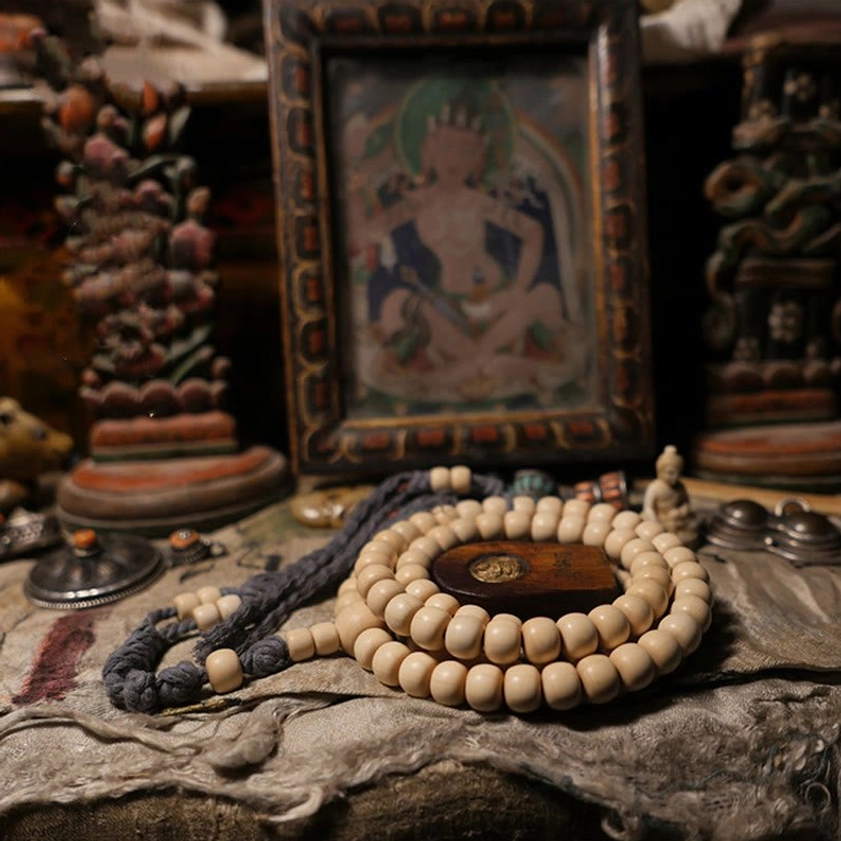 108 bead Abelia Biflora wood Buddhist prayer mala bracelet flat lay with wooden spacer and dark grey tassel