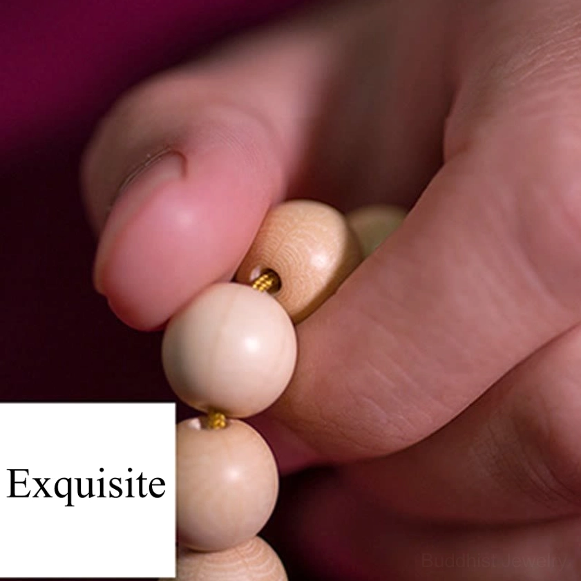 Close-up hand-held view of Abelia Biflora wood mala bracelet showing exquisite natural wood quality