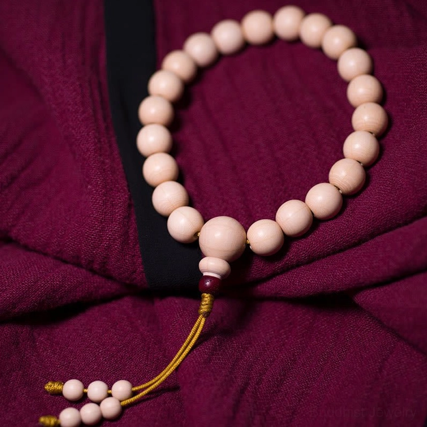 Abelia Biflora wood prayer mala bracelet side angle showing red bead and tassel detail