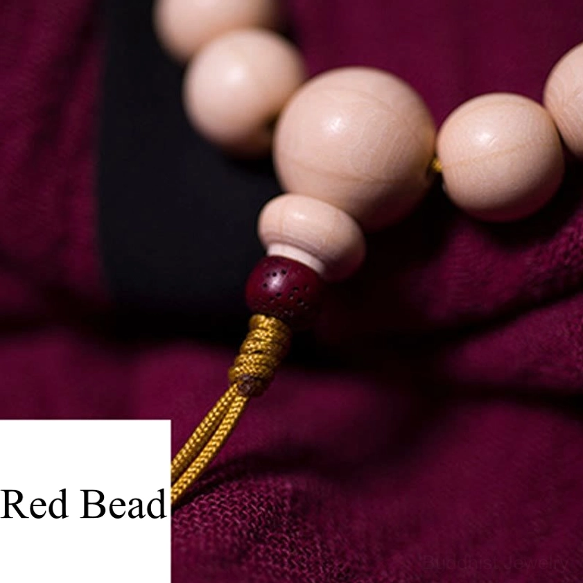 Abelia Biflora wood mala bracelet knot close-up showing red accent bead and golden tassel connection