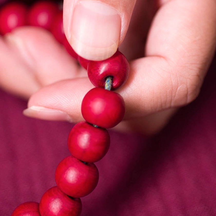 Macro close-up of natural Abelia Biflora wood mala beads six-way texture detail held between fingers