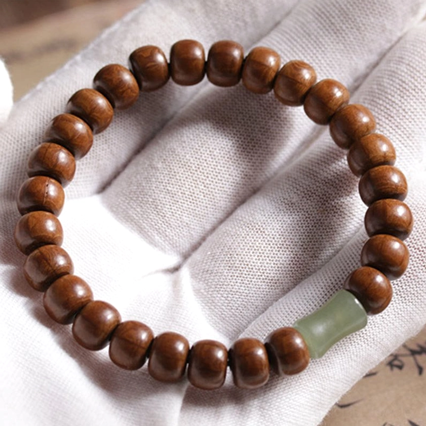 Abelia wood hetian jade bamboo bead bracelet placed on clean white gloves showing premium presentation