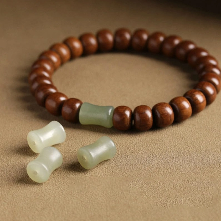 Abelia wood hetian jade bracelet with loose matching wooden beads and jade spacers on light background