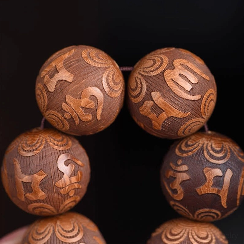 Flat lay overhead view of large carved wooden Buddhist prayer beads with full mantra engravings