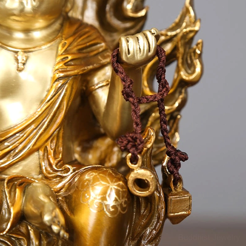 Side close-up of Acalanatha Buddha torso showing prayer rope with metal pendant and ornate robe carved details