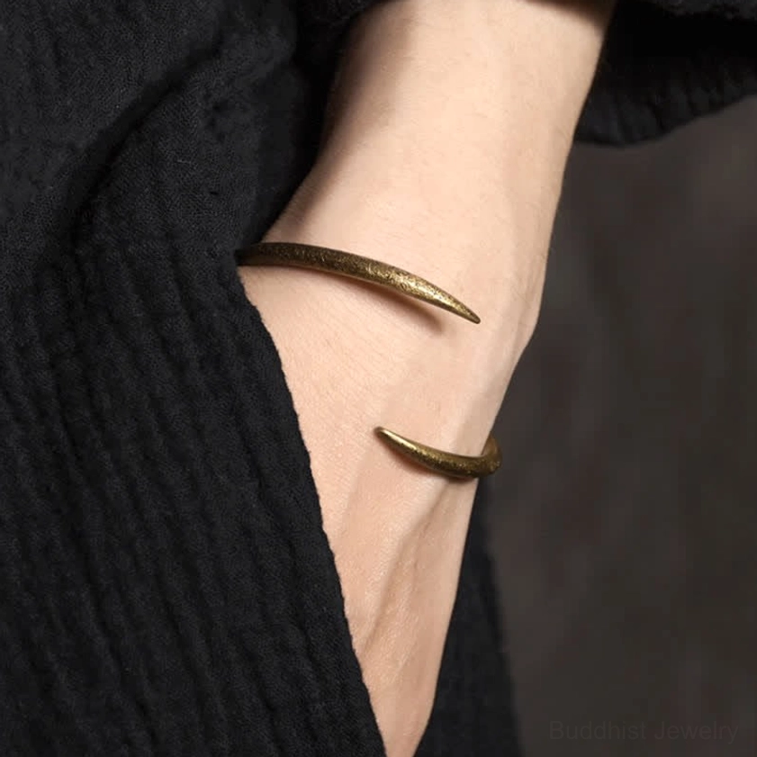 Gold copper bracelet worn on wrist with minimalist design, open adjustable cuff style spiritual Buddhist jewelry