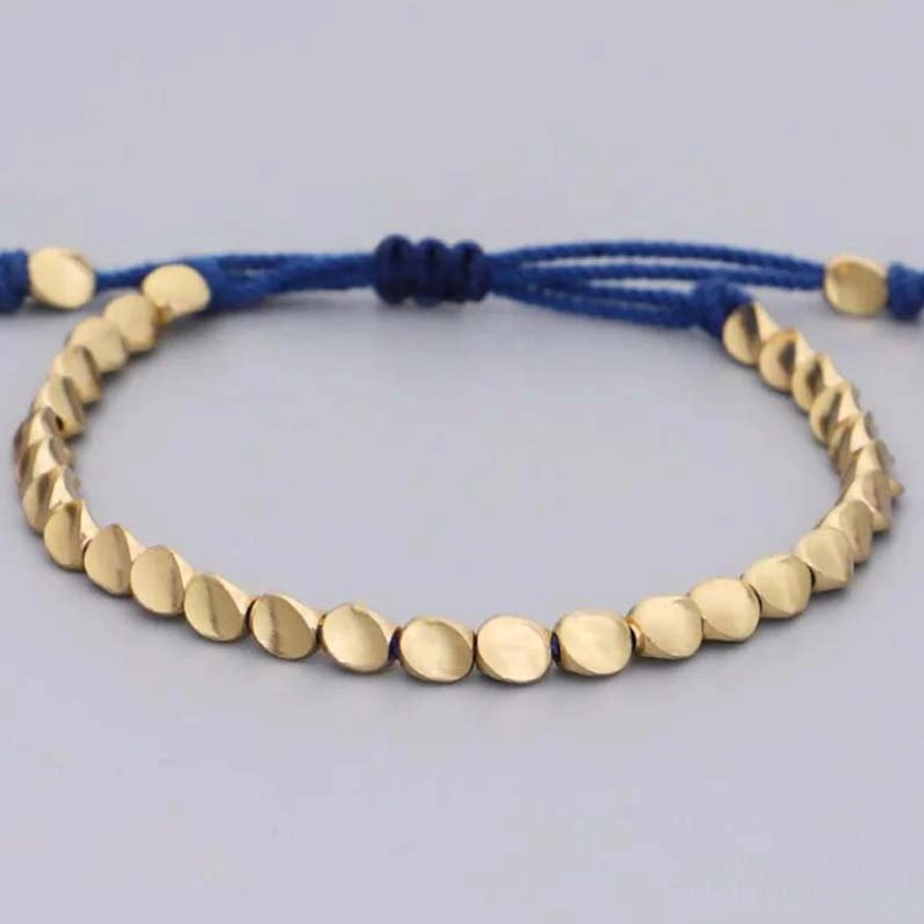 Adjustable handmade copper beaded bracelet with braided knot closure on white background