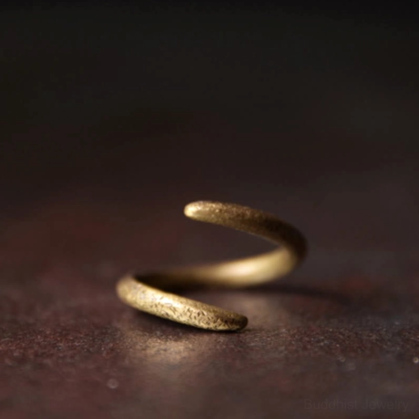 Copper spiral Buddhist ring top angle shot, warm bronze matte texture, open-spiral design