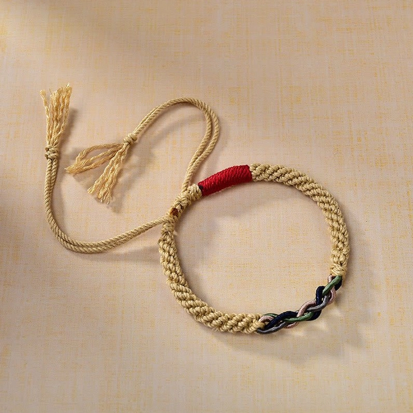 Three-quarter side angle of hand-knotted Buddhist red string bracelet with beige braided cord and multi-color twisted knot accent