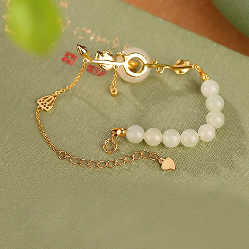 Adjustable Hetian jade chain bracelet with peace buckle shown flat lay on calligraphy paper background