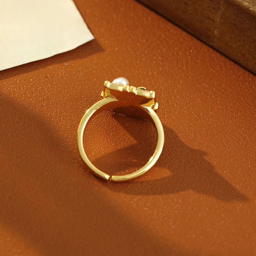 Lotus pearl copper ring rear view - adjustable open band showing back of ornament on brown leather
