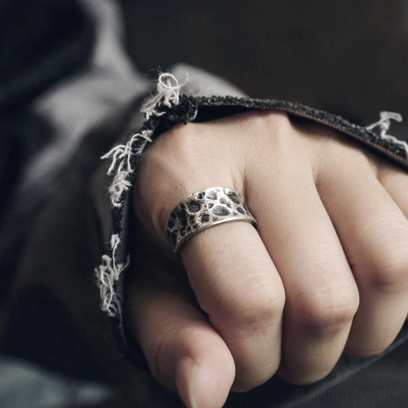 Textured Buddhist ring on finger showing spiritual protection design and handmade silver craftsmanship