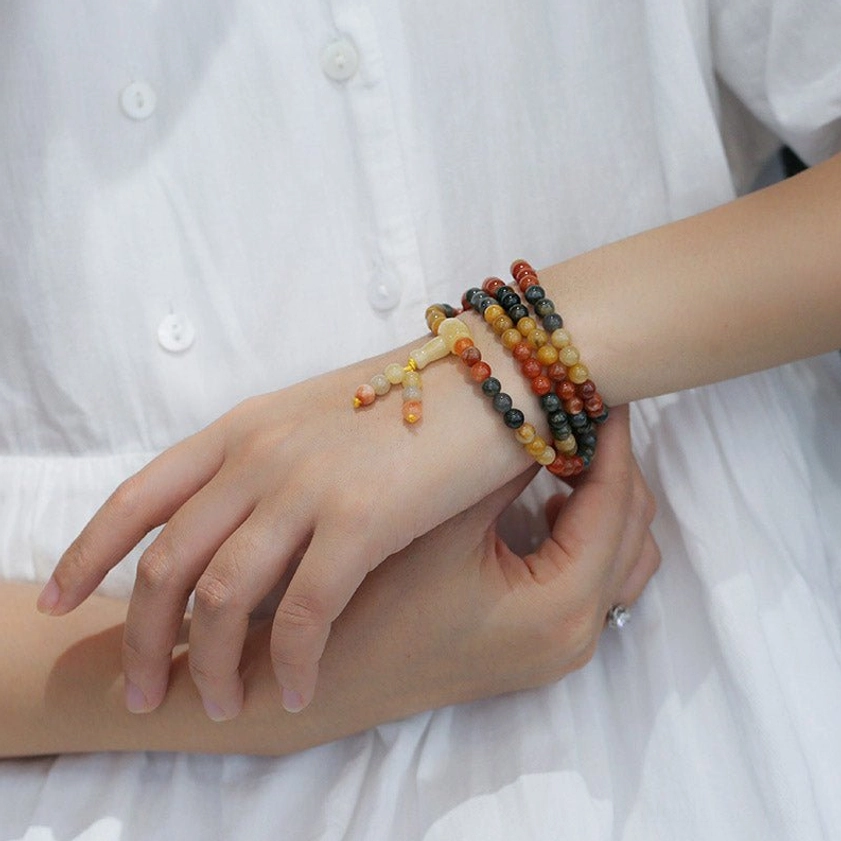 Female hands wearing red and black agate mala bracelets - prayer beads on wrist styling
