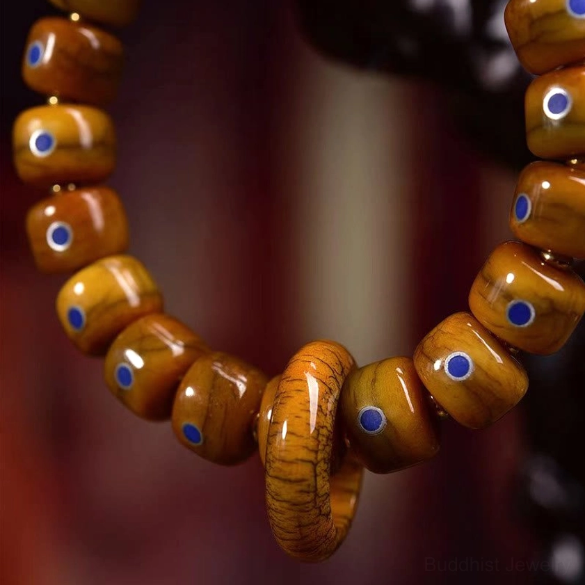 Close-up texture of vintage bone beads with blue lapis lazuli inlays and metallic accents