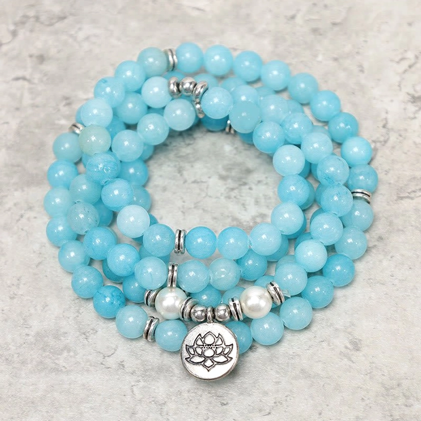 Amazonite lotus mala bracelet 8mm beads with silver spacers and lotus charm on textured surface