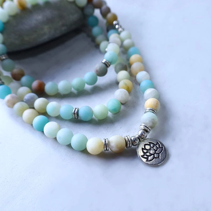 Layered amazonite lotus mala close-up side view, showing mixed-toned matte stone beads strung with silver hardware and lotus pendant charm