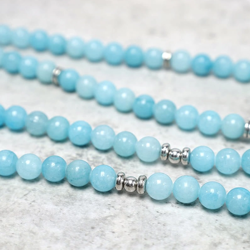 Close-up of smooth natural amazonite round beads with polished finish and silver spacer rings